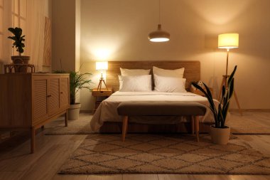 Yatak odasının içinde yumuşak yatak ve parlak lambalar var.