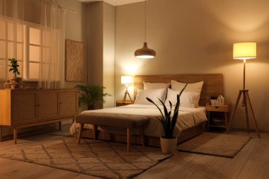 Yatak odasının içinde yumuşak yatak ve parlak lambalar var.