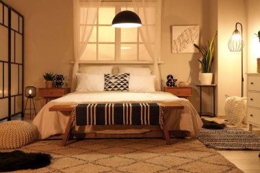 Büyük yataklı ve parlak lambalı modern yatak odası.