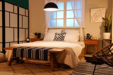 Büyük yataklı ve parlak lambalı modern yatak odası.