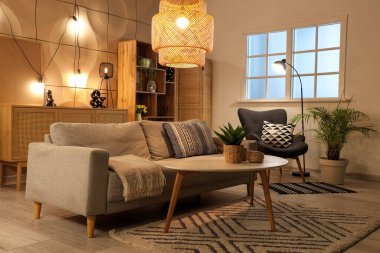 Oturma odasının içinde kanepe, sehpa ve lambalar var.