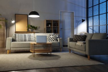 Rahat kanepeleri, masası ve parlak lambaları olan oturma odasının içinde.