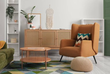 Oturma odasında rahat bir kanepe, koltuk, puf ve sehpa.