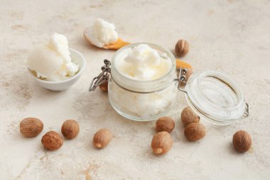 Cam kavanoz, arkaplanda tereyağı ve fındık var.