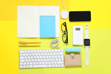 Kırtasiyeli kompozisyon ve sarı arka planda modern cihazlar
