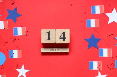 14 Temmuz tarihli küp takvimi, kırmızı arka planda Fransız bayrakları ve yıldızları. Bastille Günü kutlamaları