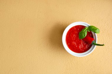 Kahverengi arka planda fesleğen ve kırmızı biberli domates sosu.