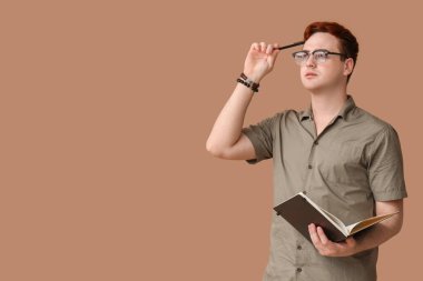 Kahverengi arka planda not defteri olan genç yazar