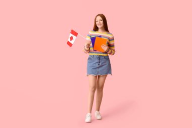 Not defterleri ve pembe arka planda Kanada bayrağı olan kız öğrenci.