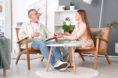 Huzurevindeki bakıcıdan bir bardak su alan yaşlı adam.