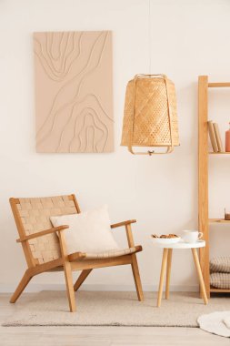 Beyaz oturma odasının içinde, rahat koltuğu ve kahve masası var.