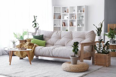 Interior of living room with soft couch and green plants