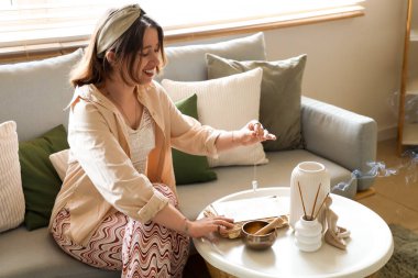 Evdeki masada sarkacı ve büyü kitabı olan genç cadı.