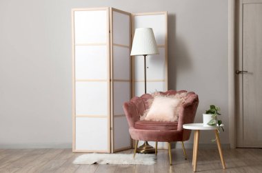 Katlanır ekran, koltuk ve masa ile oturma odasının içi