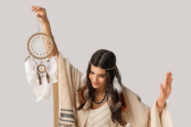 Işık arka planında rüya kapanı olan güzel bir kadın şaman.