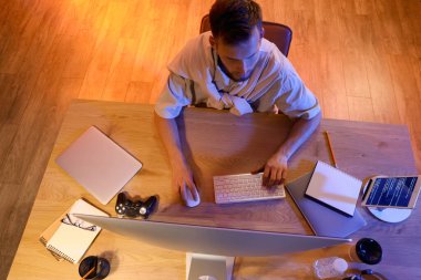 Gece ofiste bilgisayarla çalışan erkek programcı, üst görünüm