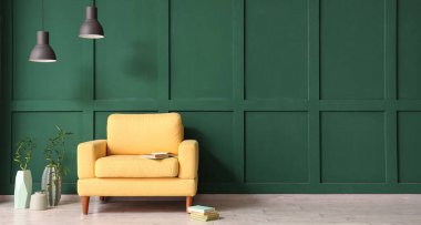 Yeşil duvarın yanındaki vazolarda şık sarı koltuklar, lambalar ve bambu. Tasarım için pankart