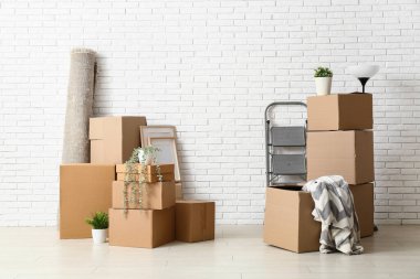 Taşındığı gün beyaz tuğla duvarın yakınındaki karton kutular.