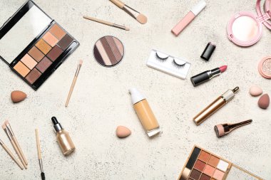 Beyaz grunge arka planında farklı makyaj ürünleri