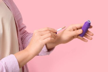 Pembe arka planda sıvı ruj izi olan kadın.