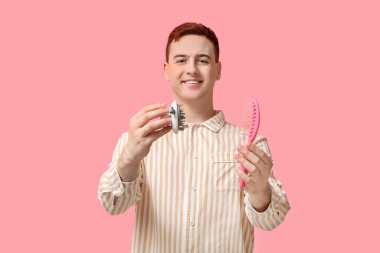 Kafa derisi masajcısı ve pembe arka planda fırçası olan mutlu genç adam.