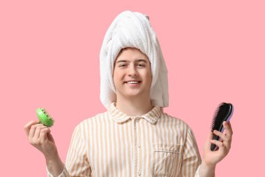 Kafa derisi masajcısı ve pembe arka planda fırçası olan mutlu genç adam.