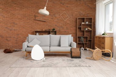 Interior of damaged living room with sofa and overturned table after earthquake clipart