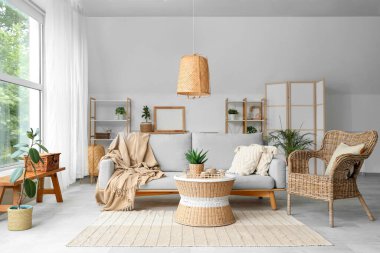 Hasır sepeti, sandalyesi ve masası olan şık bir oturma odası.