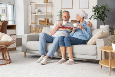 Kocasıyla kemoterapiden sonra evde çay içen olgun bir kadın.