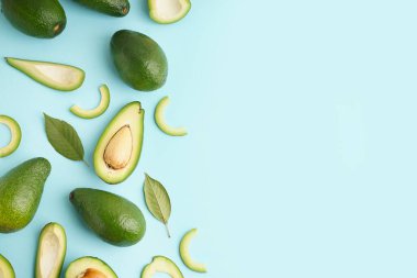 Taze olgun avokado ve yapraklar mavi arkaplanda