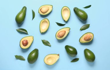 Taze olgun avokado ve yapraklar mavi arkaplanda