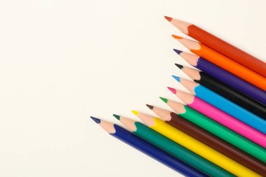 Beyaz arkaplanda farklı renkli kalemler, yakın plan
