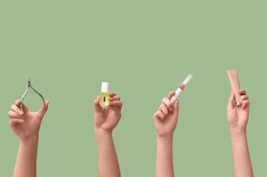 Farklı kozmetik ürünlere sahip kadın elleri ve yeşil arka planda manikür kesicisi.