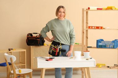 Odada aletleri olan kadın işçi.