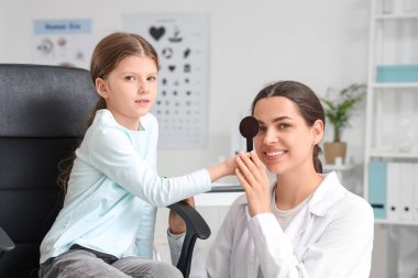 Klinikte tıkanmış ve göz doktoru olan küçük bir kız.