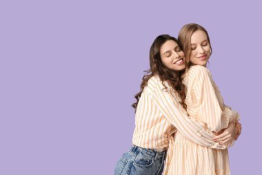 Leylak arkaplanda sarılan güzel kız kardeşler.