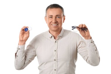 Kontak lens kutusu ve beyaz arka planda gözlüğü olan mutlu olgun bir adam.