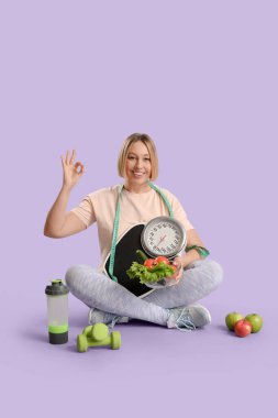 Pul ve taze sebzeli güzel bir bayan leylak arka planda iyi görünüyor. Kilo verme konsepti