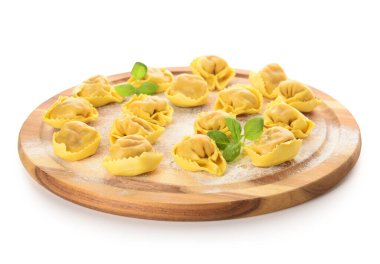 Tahta tahta, çiğ hamur köftesi ve beyaz arka planda fesleğen.