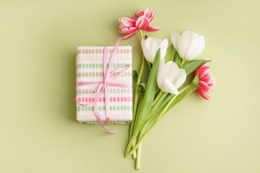 Hediye kutusu ve yeşil arka planda güzel laleler.