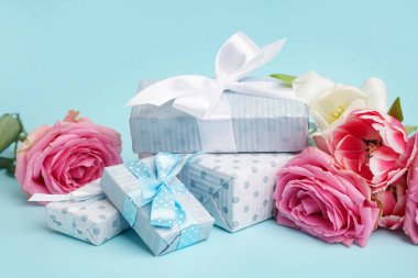 Güzel laleli hediye kutuları ve mavi arka planda pembe güller.