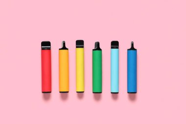 Pembe arka planda farklı elektronik sigaralar.