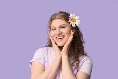 Saçında papatya çiçeği olan güzel bir kadın leylak arka planda