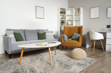 Kanepesi, koltuğu ve masası olan modern oturma odası.