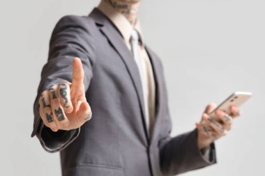 Cep telefonlu genç işadamı arka planda sanal ekran kullanıyor, yakın plan