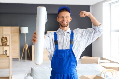 Odada esnek ambalajlı erkek işçi.