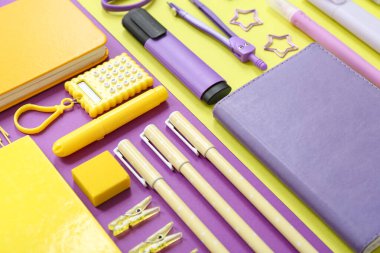 Mor arkaplanda farklı kırtasiye malzemesi, yakın plan