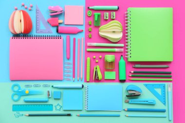 Renk arkaplanı üzerinde not defterleri ve kırtasiye ile kompozisyon