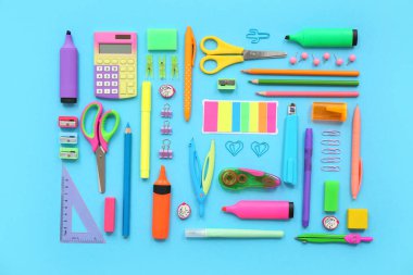 Mavi arkaplanda farklı kırtasiye malzemesi olan kompozisyon