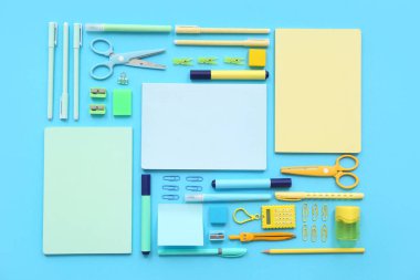 Mavi arkaplanda farklı kırtasiye malzemesi olan kompozisyon